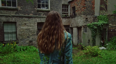 a woman standing in front of an old building