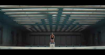 a woman standing on a suitcase in a building