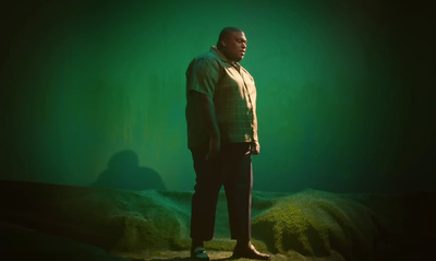 a man standing in front of a green background