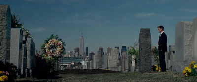 a man in a suit standing in a cemetery