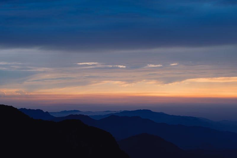 a person standing on top of a mountain at sunset