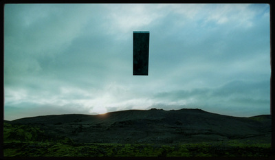 a kite flying in the sky over a mountain