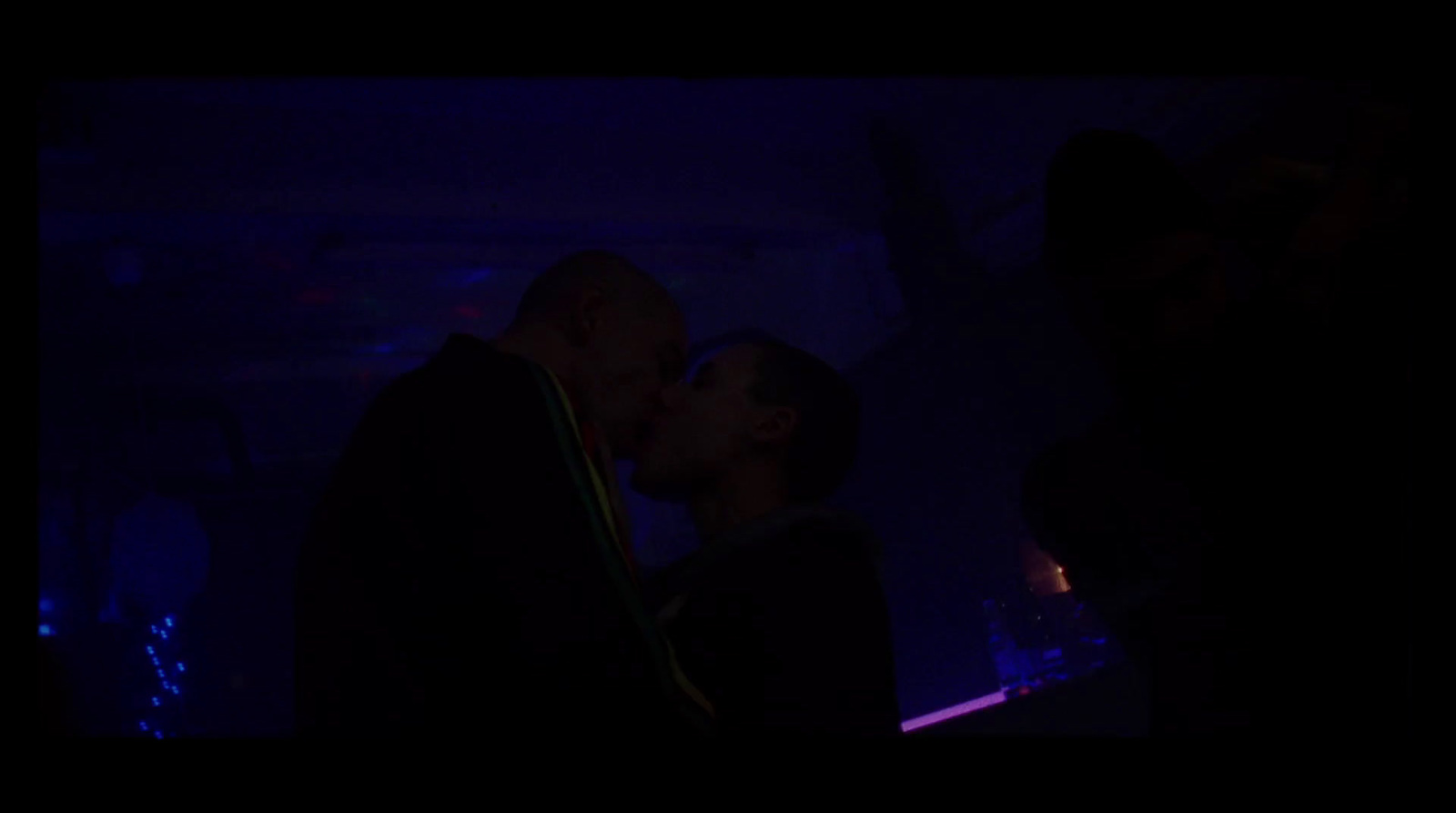 a man and a woman kissing in a dark room