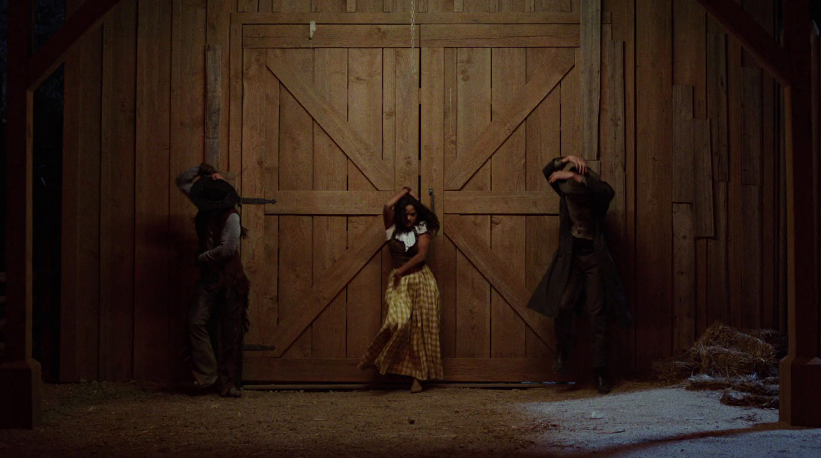 three people standing in front of a barn door