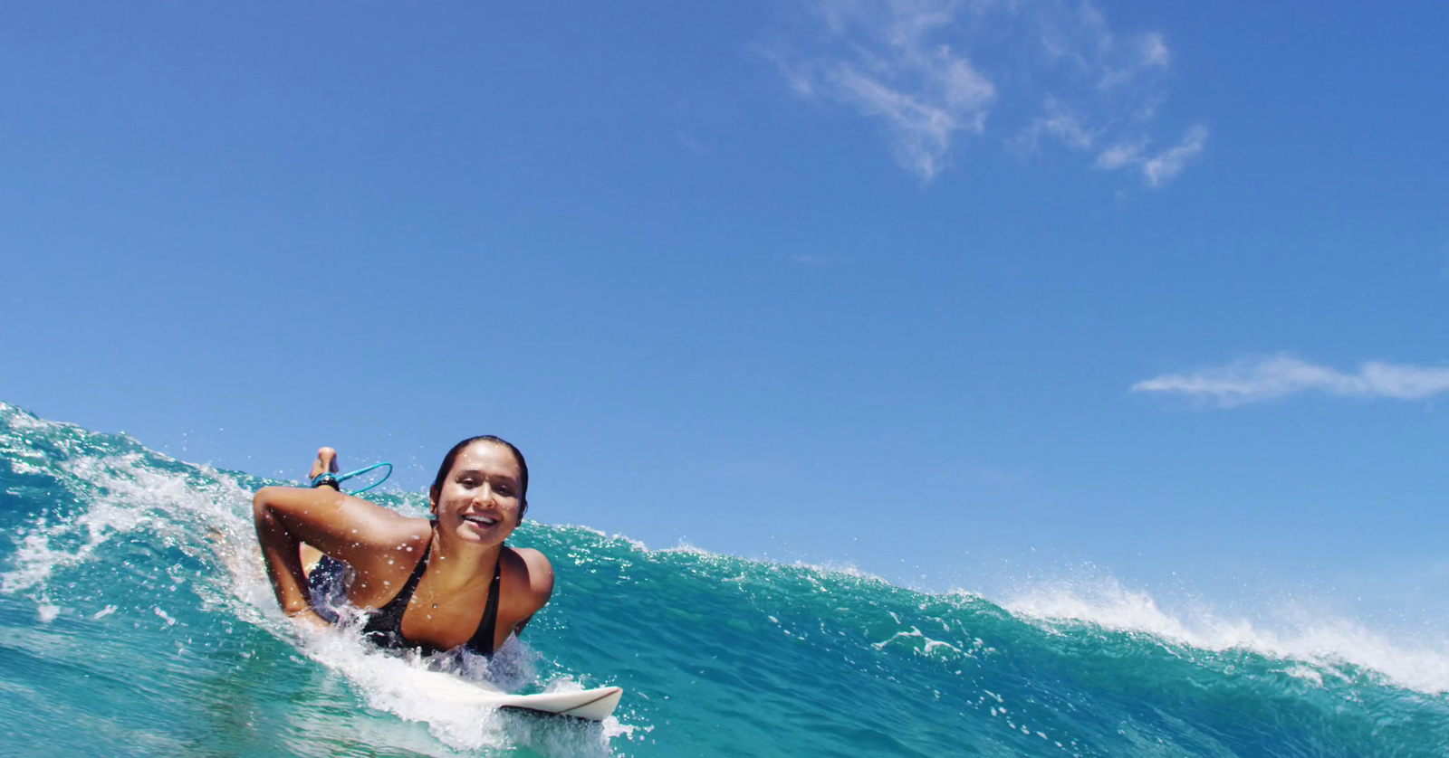 a woman riding a wave on top of a surfboard