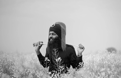 a man with a long beard is standing in a field