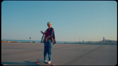 a man riding a skateboard across a parking lot