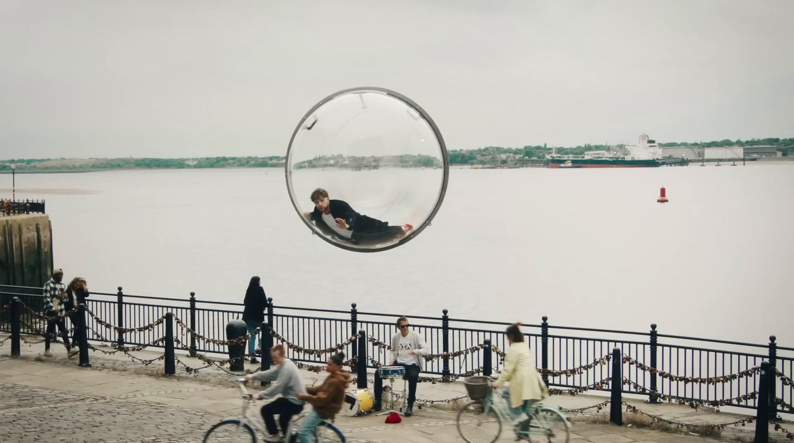 a group of people riding bikes next to a body of water