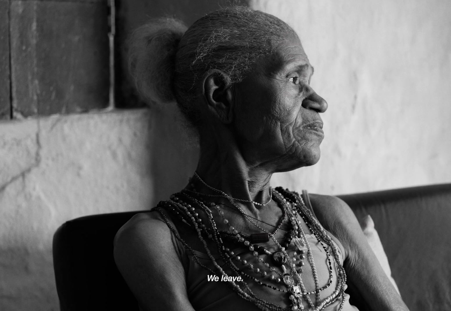 an old woman sitting on a couch in a room