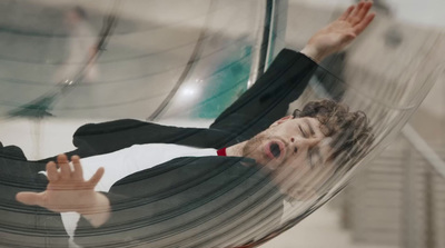 a man laying in a hammock with his hands in the air