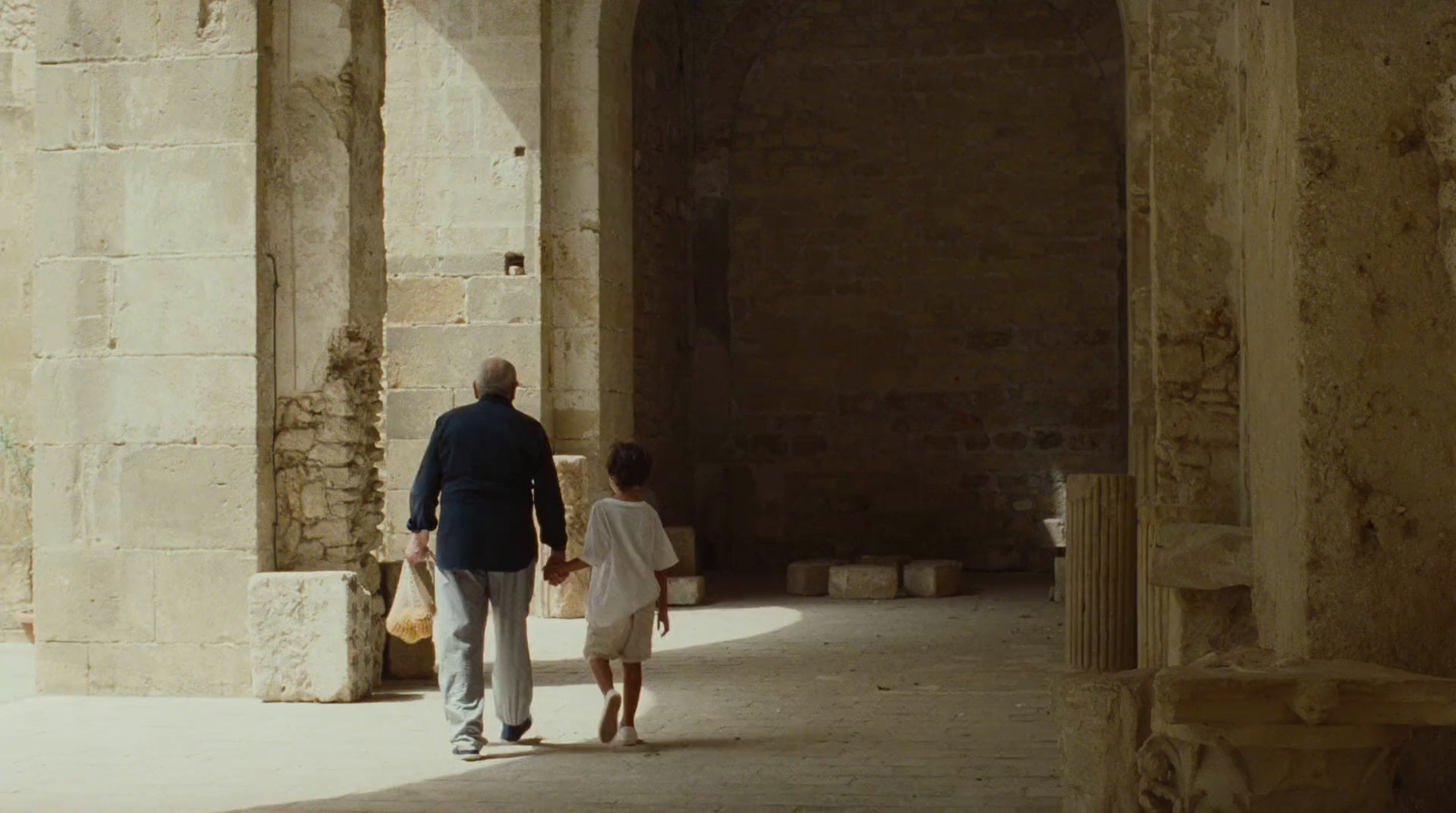 a man and a little girl walking through an archway