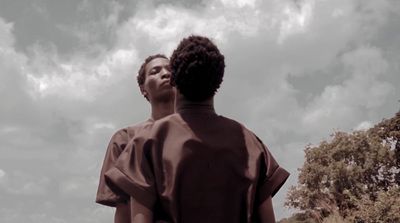 two people standing in front of a cloudy sky