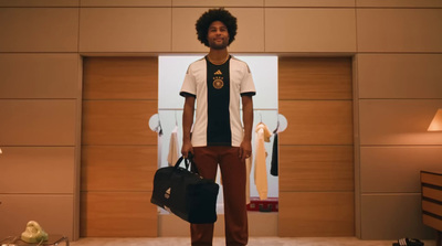 a man standing in front of a closet holding a black bag