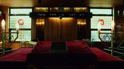 a room with stained glass windows and a red blanket on the floor