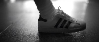 a close up of a person's shoes on a wooden floor