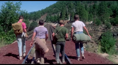 a group of people walking down a dirt road