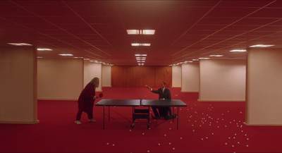 two people sitting at a table in an empty room