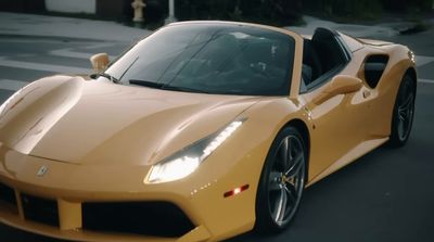 a yellow sports car driving down a street