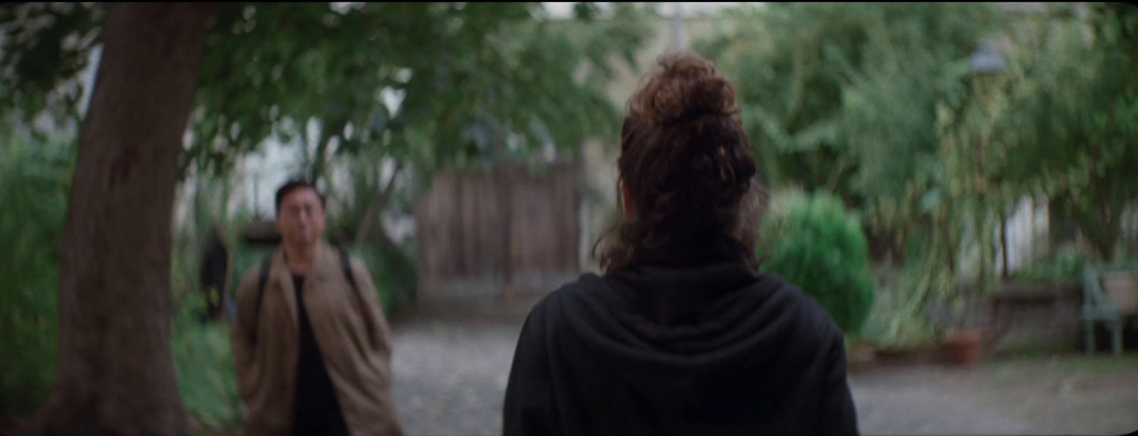 a man and a woman walking through a park