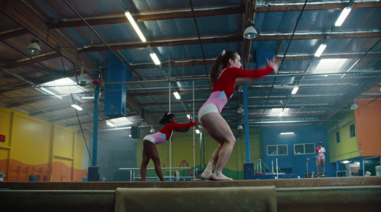 two women in red and white leotards on a trampoline