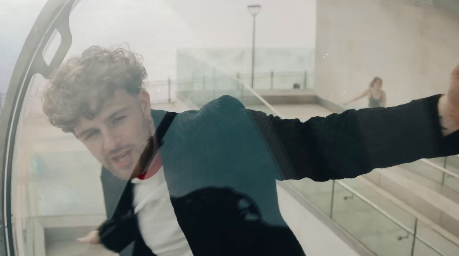 a man in a suit and tie standing in front of a window