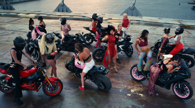 a group of women standing around a group of motorcycles