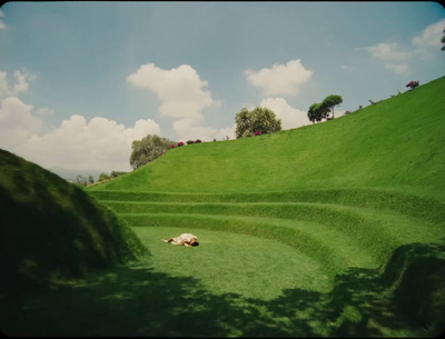 a person laying in the grass on a hill