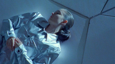 a woman laying on the ground in a silver suit