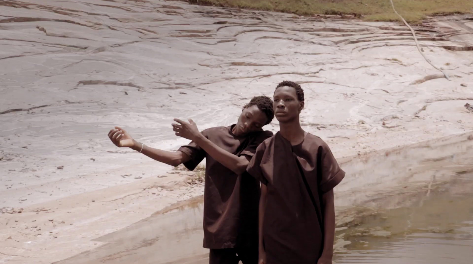 a couple of people standing next to a body of water