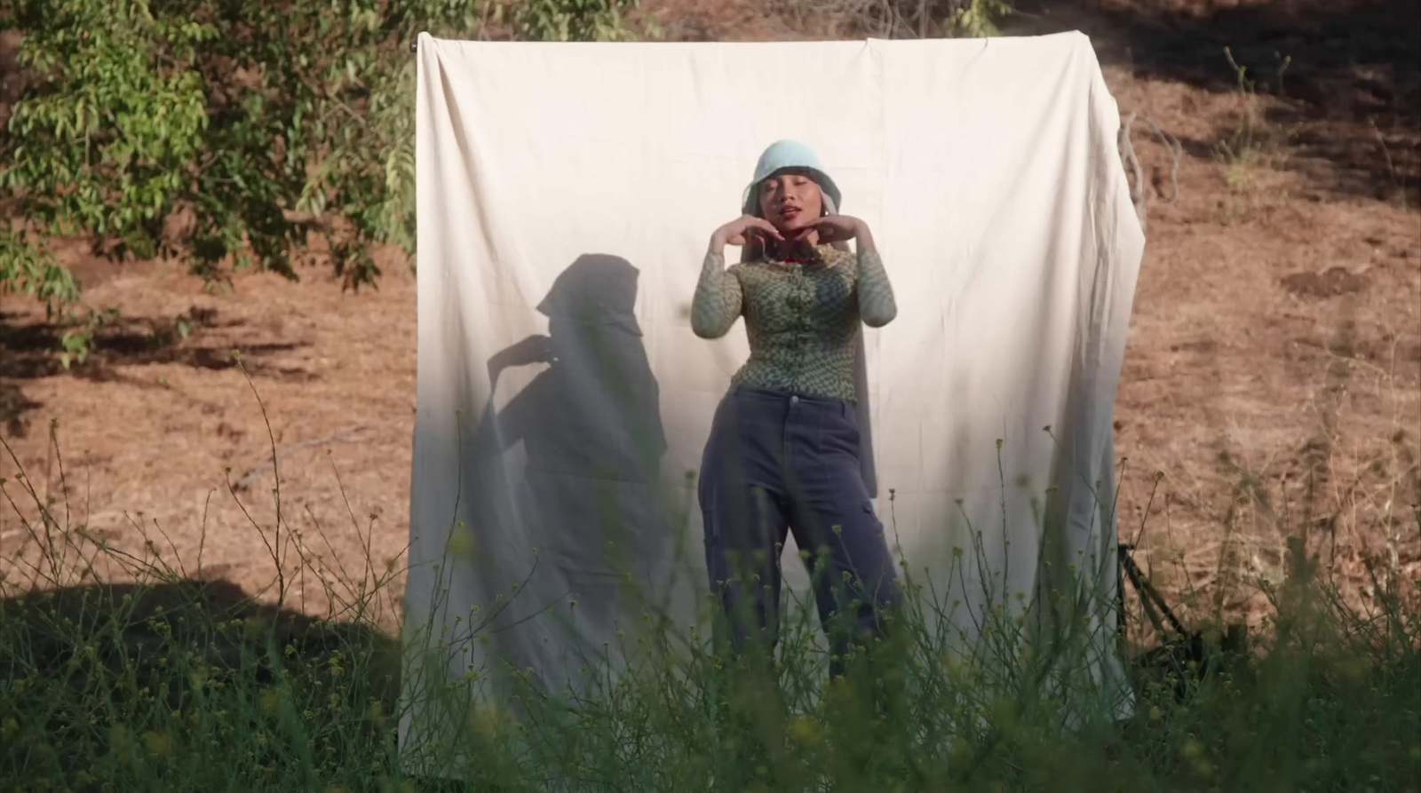 a woman standing in front of a white sheet