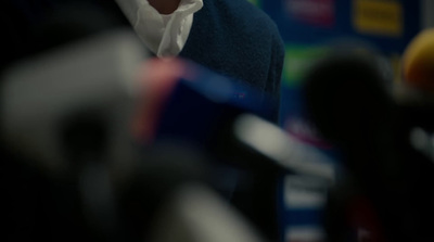 a close up of a person wearing a suit and tie