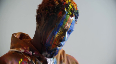 a man is covered in multicolored paint