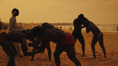 a group of people standing on top of a sandy beach