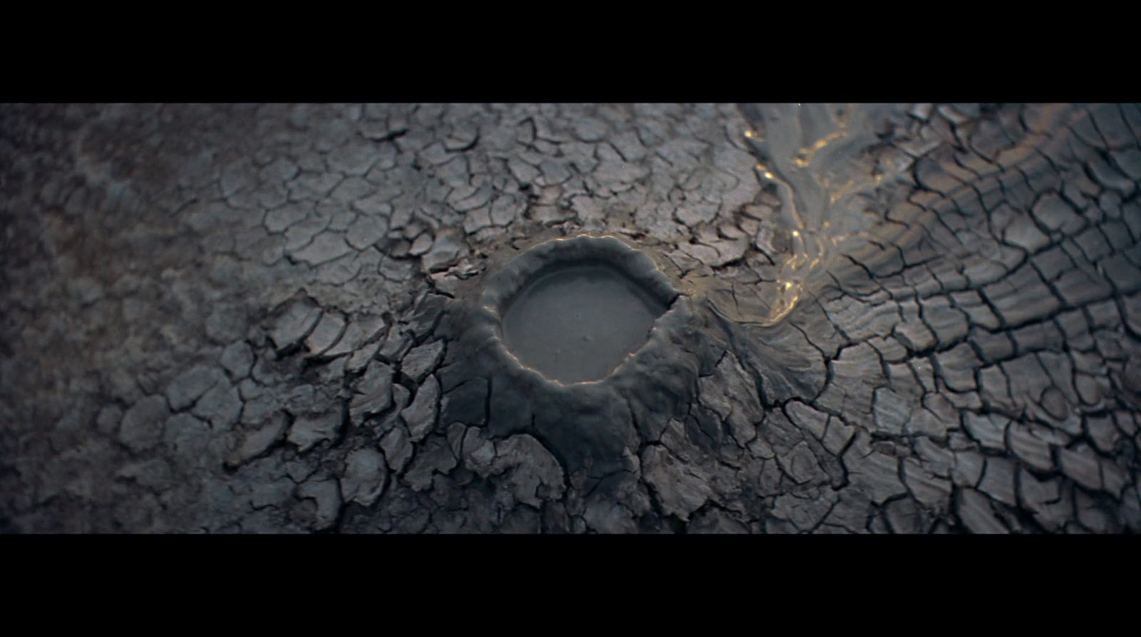 a hole in the ground with water coming out of it