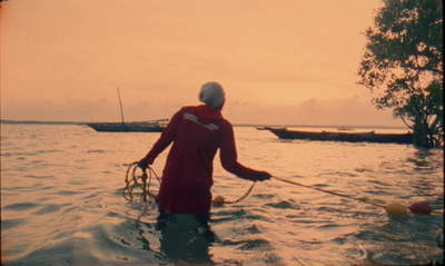 a man wading in the water with a net