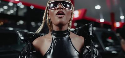 a woman in a leather outfit and sunglasses