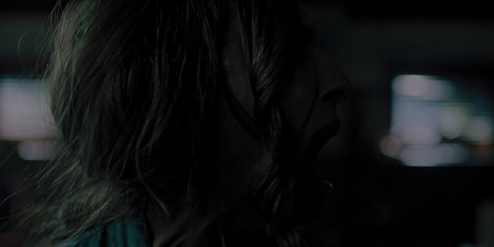 a woman with long hair standing in a dark room