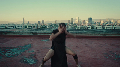 a woman in a black dress standing on a roof