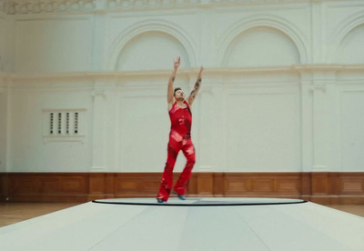 a man in a red suit is standing on a stage