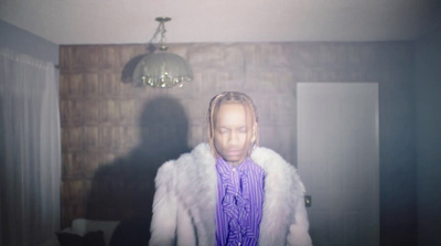 a woman in a fur coat standing in a room