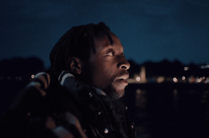 a man standing in front of a body of water at night