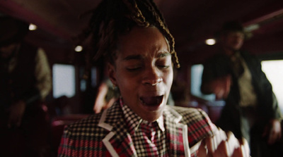 a man with dreadlocks eating food on a train