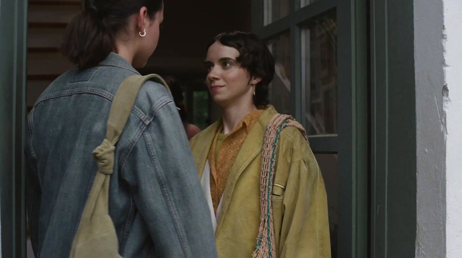 two women standing outside of a building talking