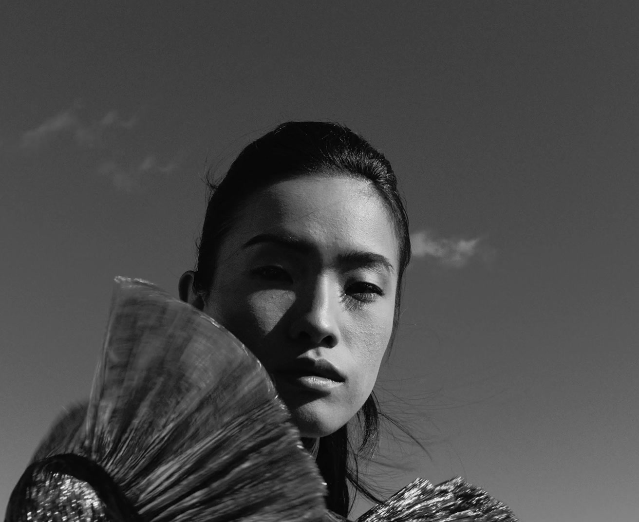 a woman is holding a fan in her hand