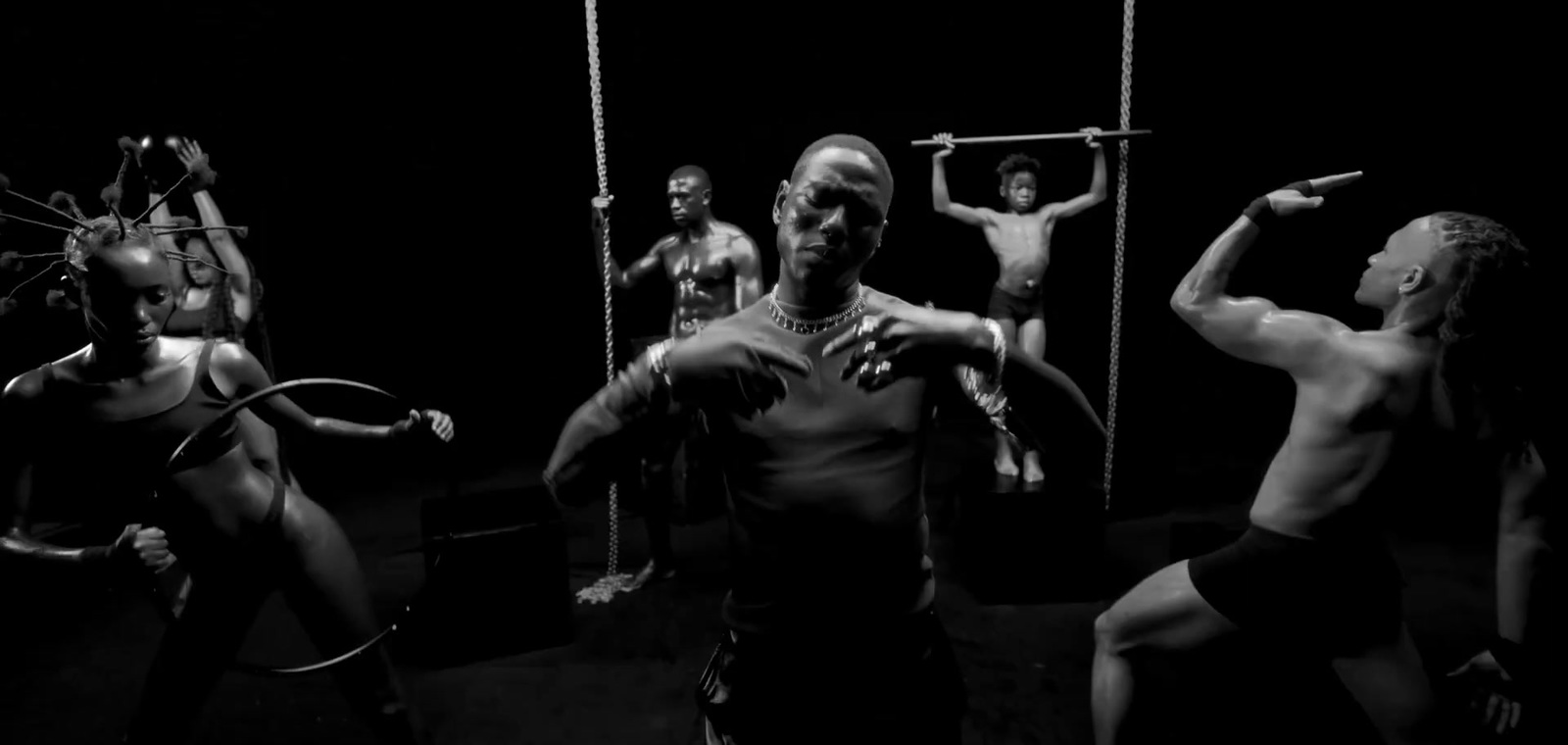 a black and white photo of a group of people doing aerial acrobatics