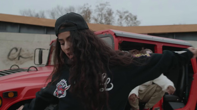 a woman with long hair standing in front of a red truck