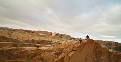 two people standing on top of a cliff