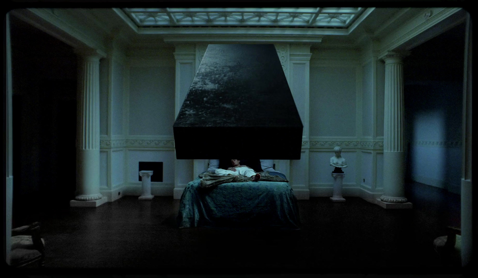 a person laying in a bed in a dark room