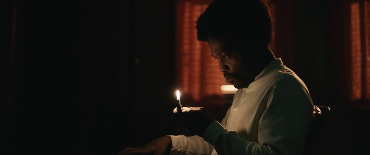 a man sitting in a chair holding a lit candle