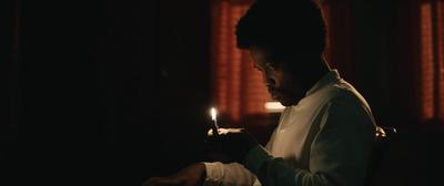 a man sitting in a chair holding a lit candle